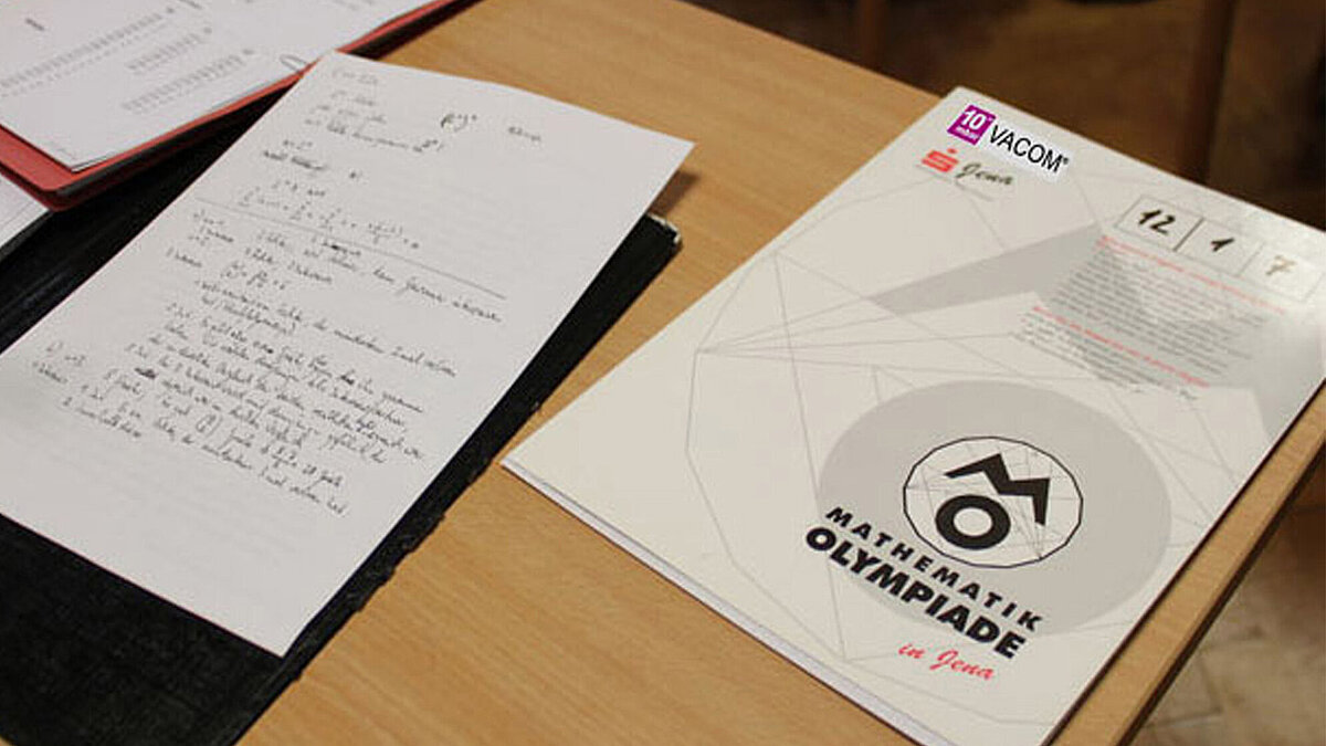 On a table are various documents for a mathematics Olympiad