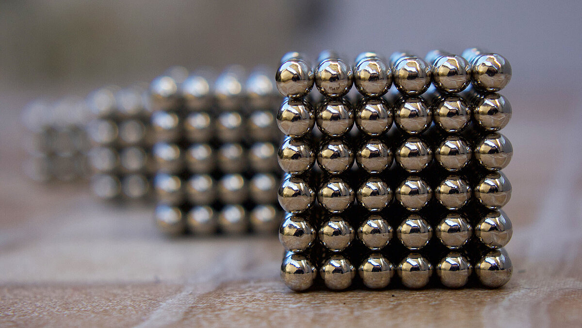 Metal spheres arranged in a cube shape as a model of the material structure.