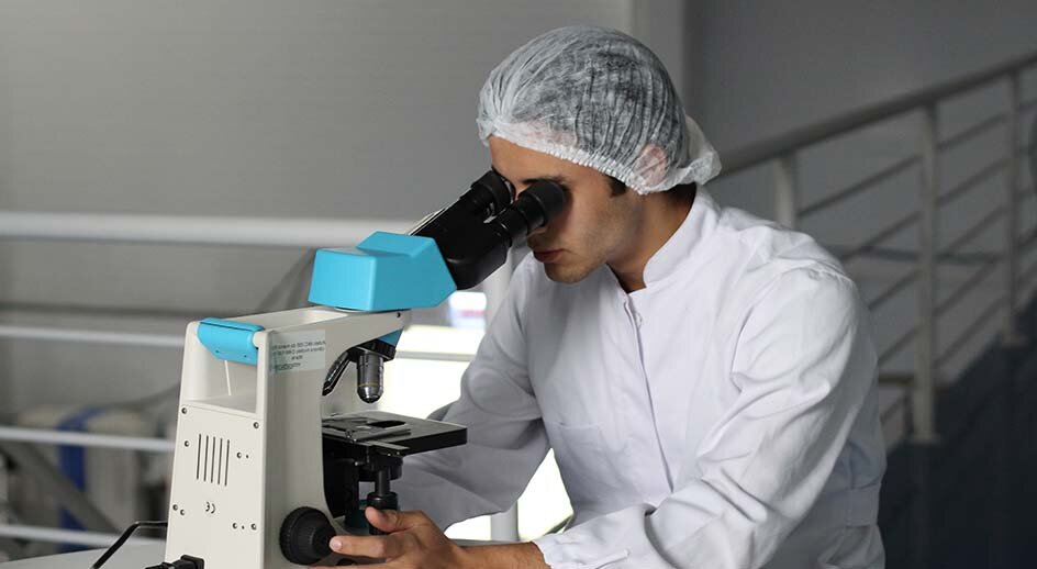 https://unsplash.com/photos/9vnACvX2748 Forschung und Entwicklung; Mann im Labor schaut durch Mikroskop 