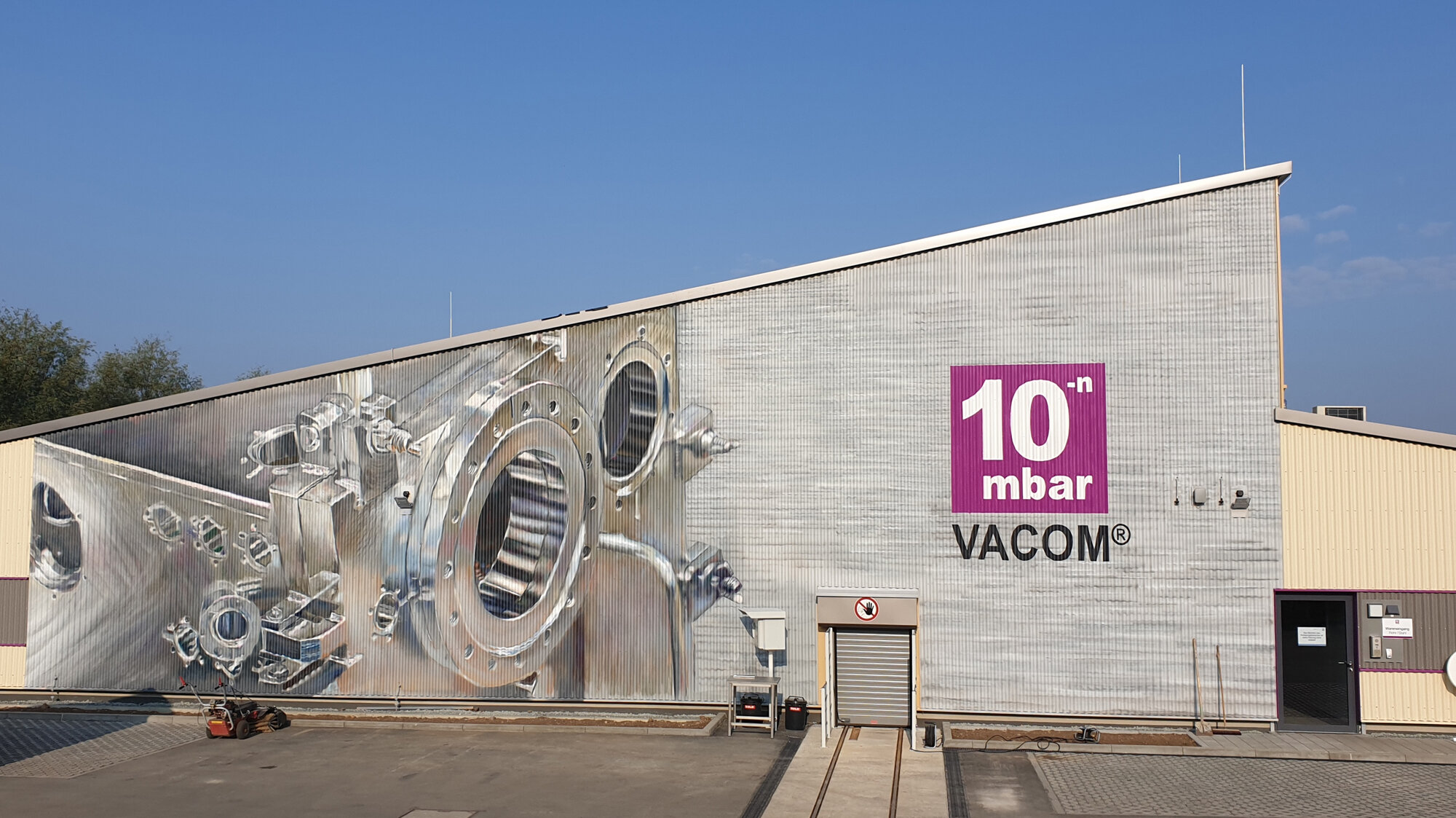Image about VACOM; Exterior facade with a chamber graffity on the production hall.