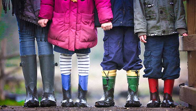 Children in rainwear stand next to each other